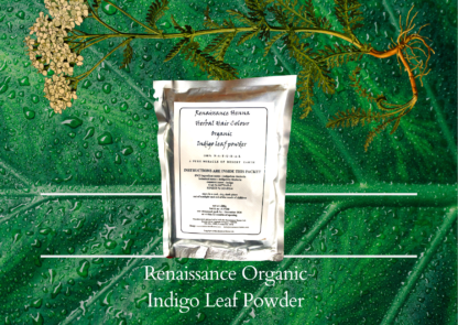 natural black hair dye product image of sealed foil packet of organic indigo powder, displayed against a green plant background and flower