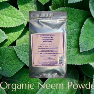 natural hair care product organic neem in silver foil packet with light pink label, displayed against a green leafy background
