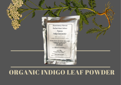 natural black hair dye organic indigo powder image against a grey background with plant flower herb across the top above the packet of natural hair dye