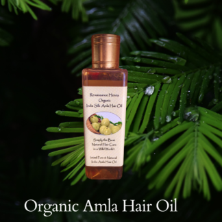 organic amla hair oil for healthy hair , product image against green leaves background