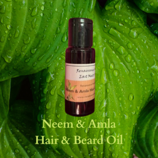 mens natural beard oil product image of small dark bottle of neem and amla natural hair care and beard oil, against a green leaf background
