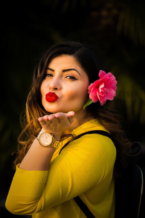 Henna is for healthy hair and henna is for good health; picture of lady with pink flower in her hair, blowing a kiss