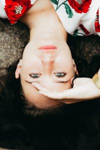 Amla natural; skin cleanser; photo of young woman lying on the ground, staring up at the amera, with dark hair and beautiful clear skin