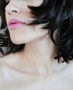 100% Professional Herbal Hair Dye, Renaissance Henna. are herbal hair colour specialists; profile of bottom half of woman's face, highlighting her pink lipstick and choppy black hair cut