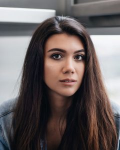 natural hair dye is PPD free, and it has no history of hair dye deaths; young woman with long straight brown hair looking straight 