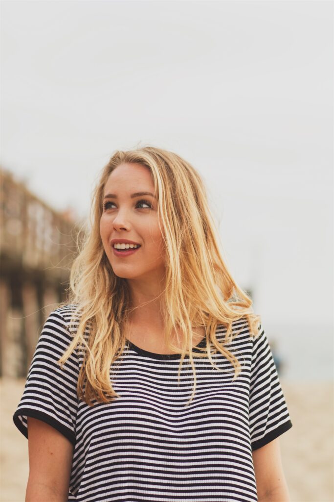 woman with shoulder length blonde hair wearing stripey T shirt