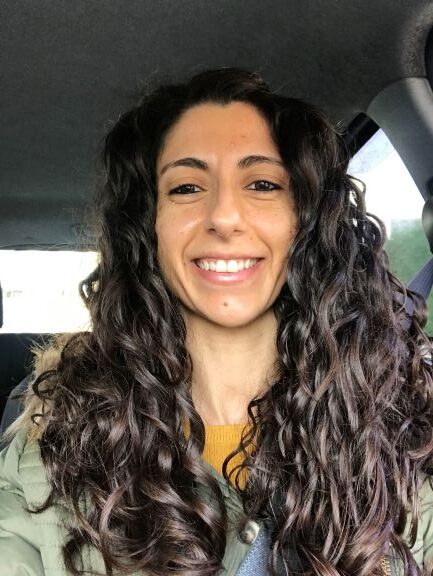 Zara with glossy brown waves after henna and indigo, front-facing in car