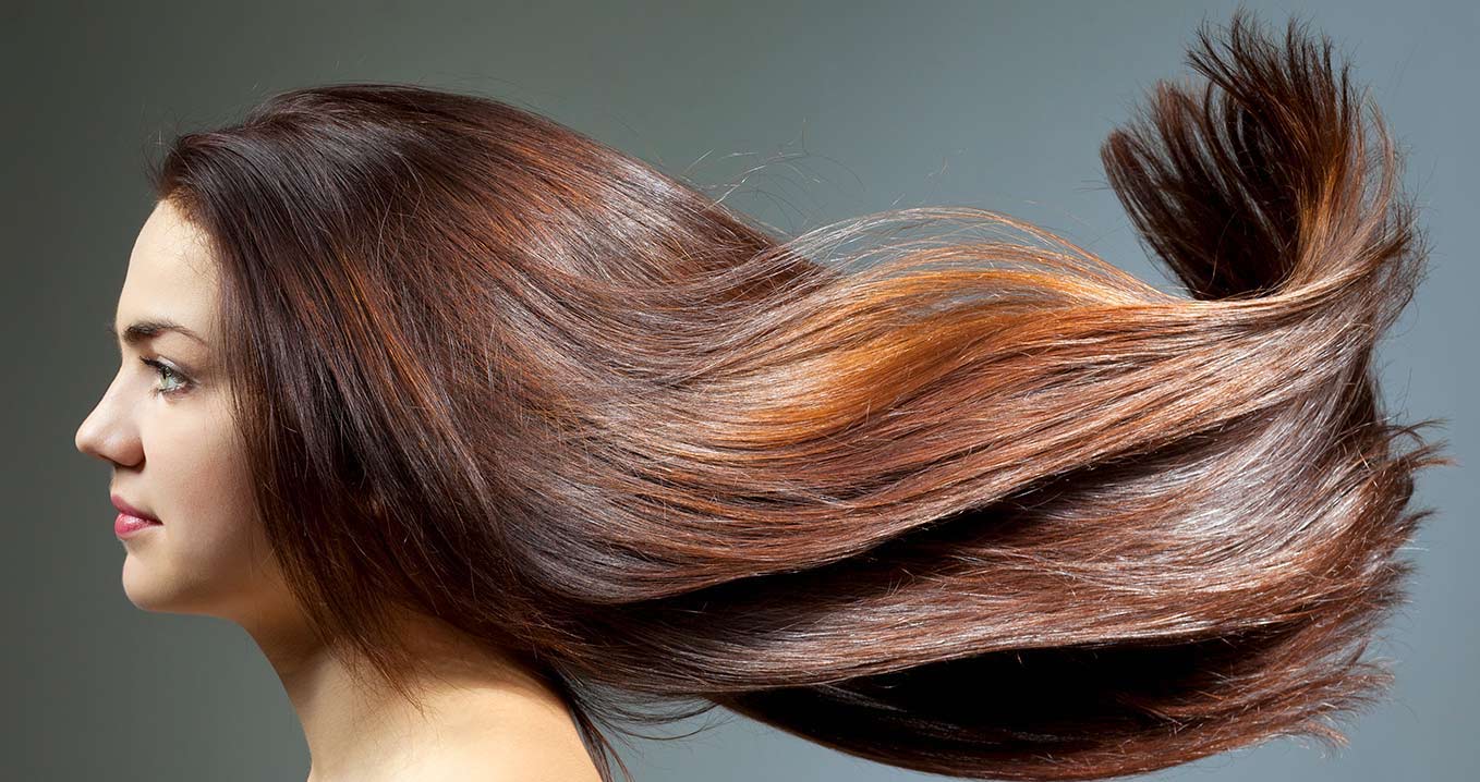 Woman with long,shiny auburn hair, side profile, healthy hair for sensitive scalp